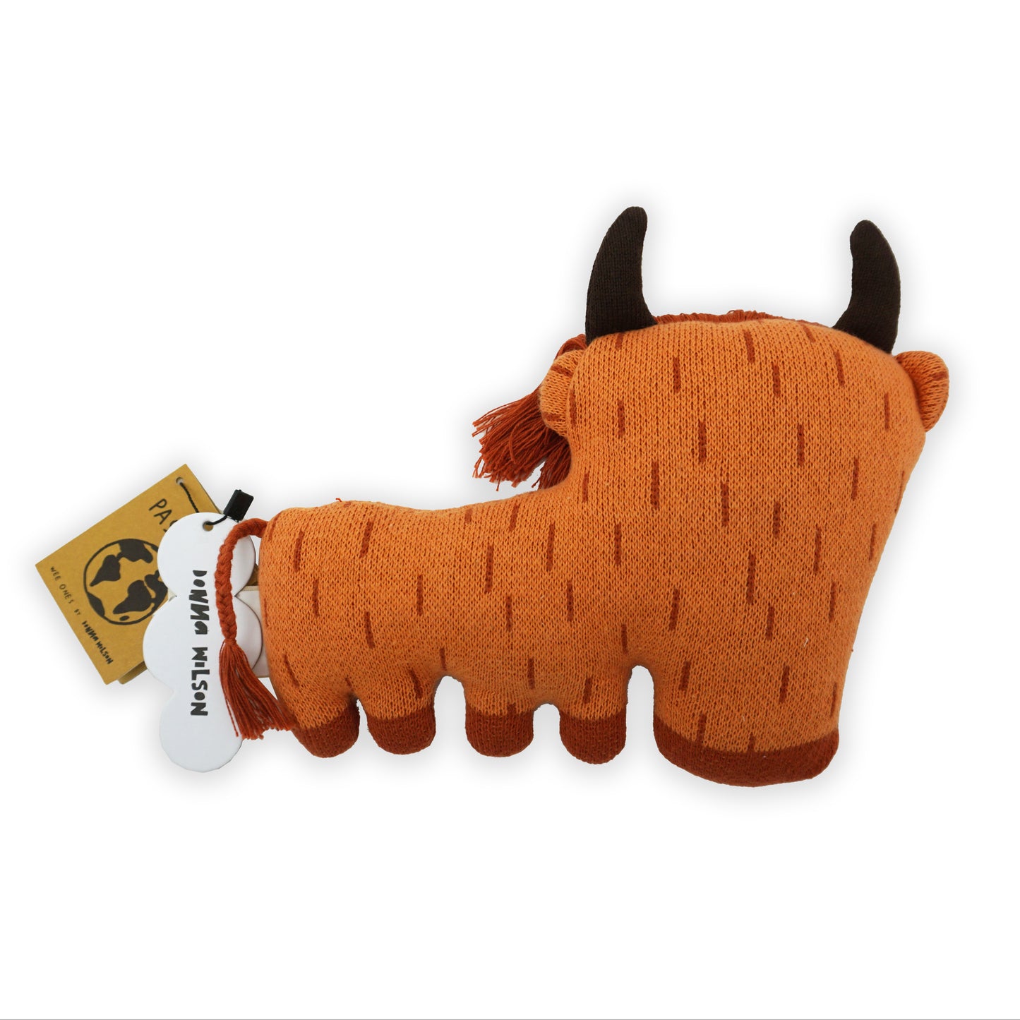 The back of a stylised stuffed orange, brown and red soft toy highland cow with horns and a long fringe and plated tail.