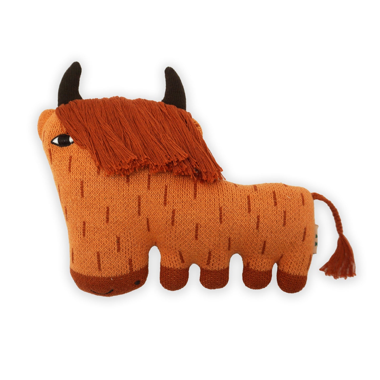 A stylised stuffed orange, brown and red soft toy highland cow with horns and a long fringe and plated tail.
