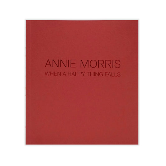 A deep red book cover featuring the embossed title "ANNIE MORRIS" and the subtitle "WHEN A HAPPY THING FALLS" in a modern, sans-serif font. The design is minimalist, with no additional images or text.