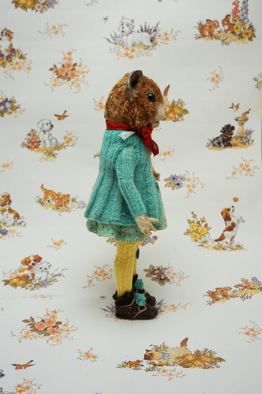 A plush guinea pig dressed in a teal cardigan, floral dress, and yellow tights holds a small stuffed animal. The background features whimsical illustrations of animals and nature scenes.