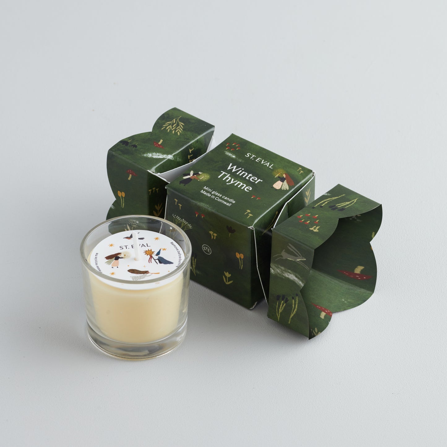 A small glass candle in a decorative box with 'St Eval' branding, featuring a stars and crescent moon design, and labelled 'Winter Thyme'.