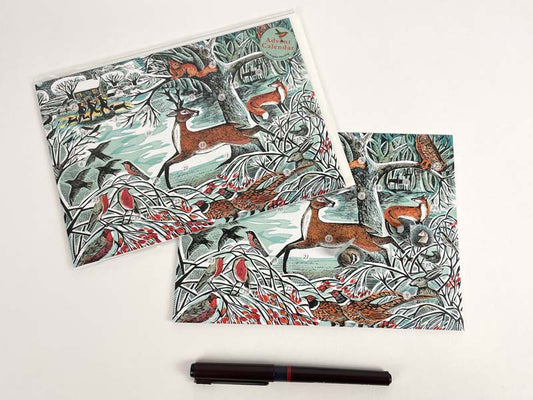 A decorative Advent Christmas card featuring a winter woodland scene with animals, birds, and a tree.