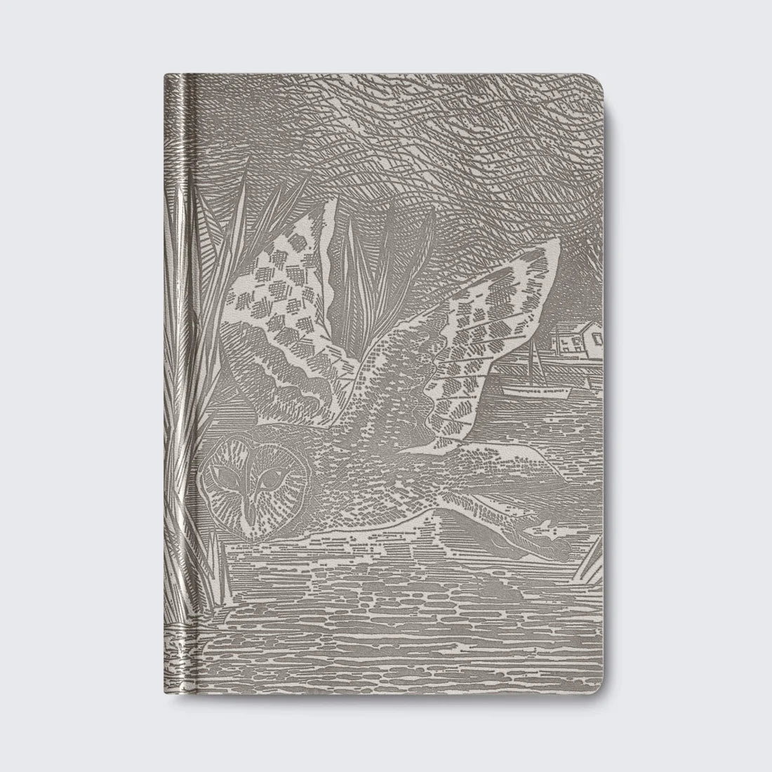 A grey notebook featuring an intricate illustration of an owl in flight, surrounded by reeds and a serene water scene. The design is detailed and textured, creating a striking visual effect on the cover.