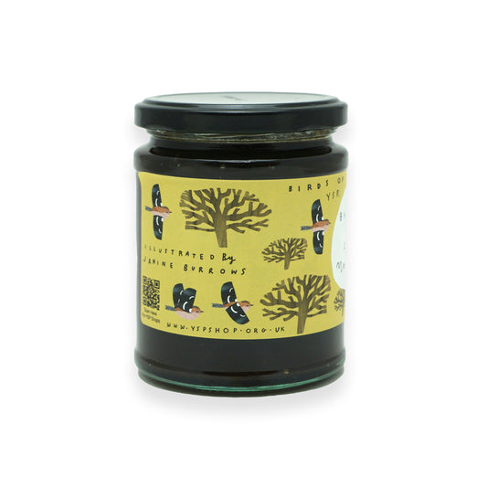 A glass jar with a black lid and a yellow label featuring illustrations of British birds and trees.