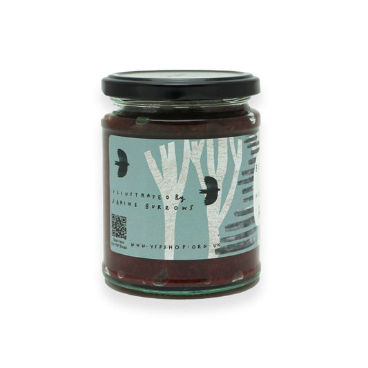 A glass jar with a black lid and blue label featuring illustrations of trees and birds.