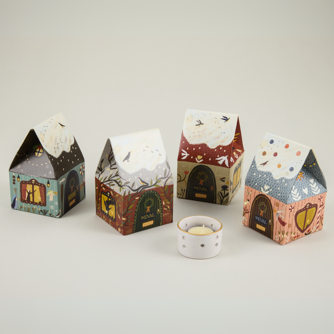 Four house-shaped paper boxes with decorative designs on a light gray background.