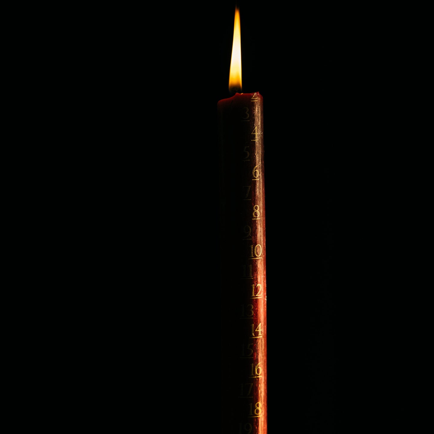 Candle with a lit wick on a black background