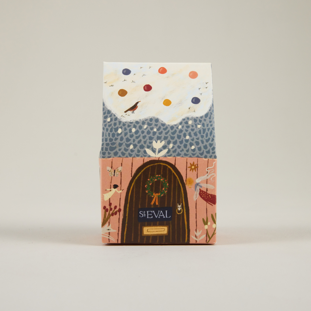 St Eval paper cottage packaging featuring a snowy roof and brown door.