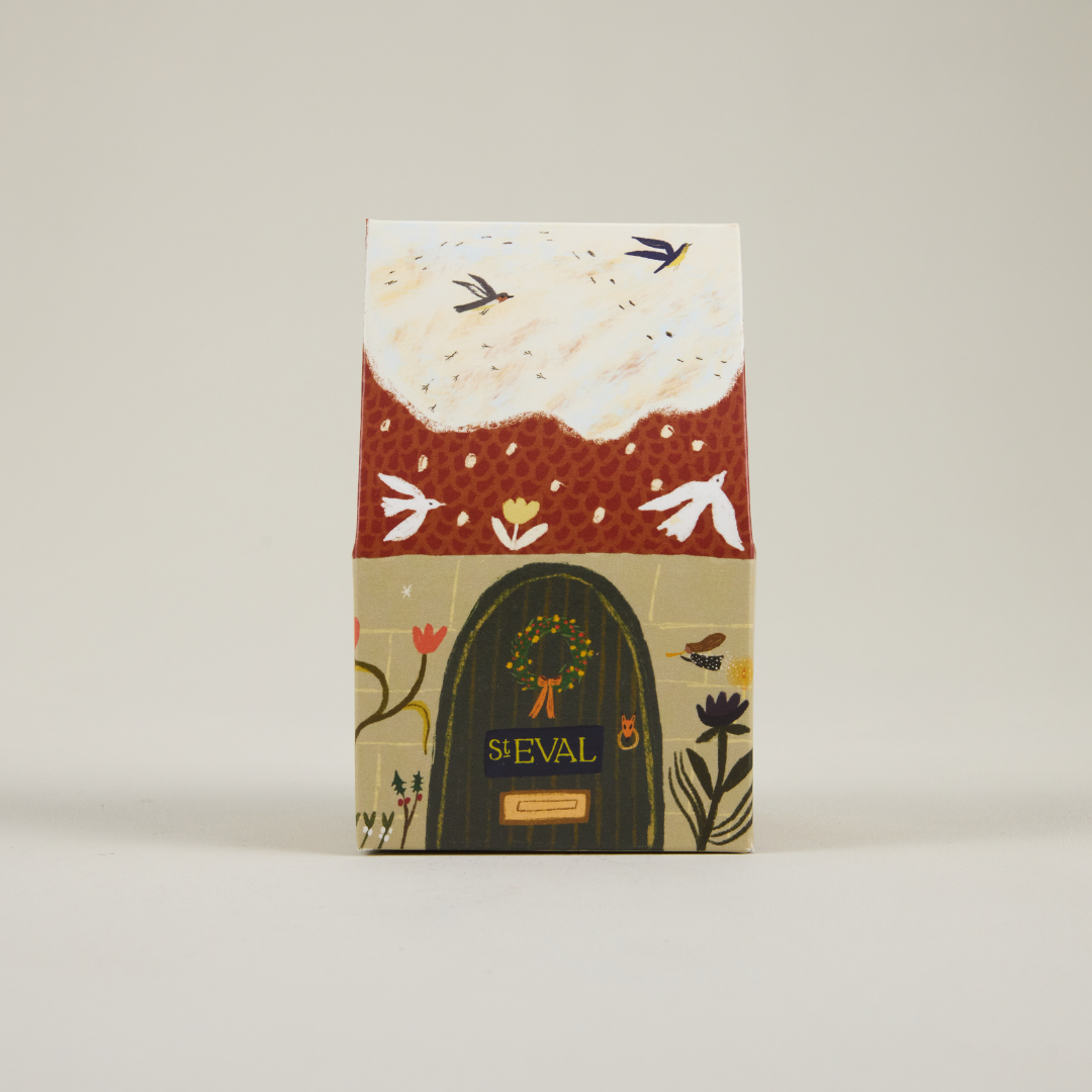 St Eval paper cottage packaging featuring a snowy roof and brown door.