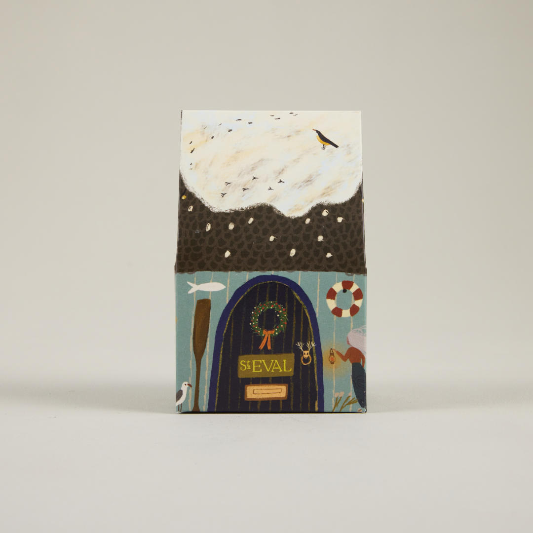 St Eval paper cottage packaging featuring a snowy roof and brown door.