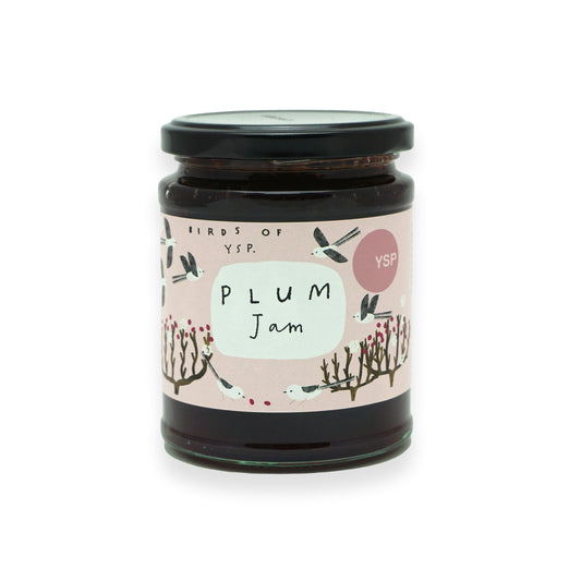 A glass jar with a black lid and pink label that features illustrations of birds and trees.