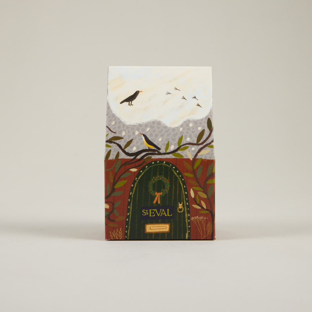 St Eval paper cottage packaging featuring a snowy roof and brown door.