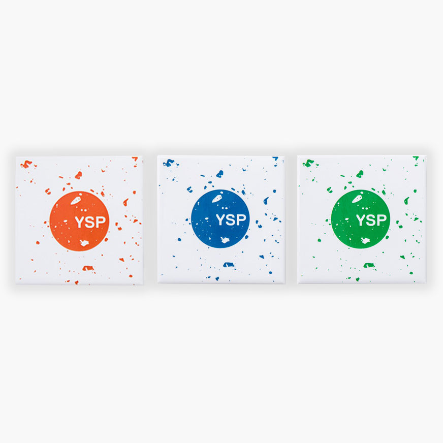 Three square fridge magnets featuring a central circle with the letters "YSP" in white. The left canvas has an orange background with splatters, the middle one is blue, and the right one is green, each with a similar splatter design.