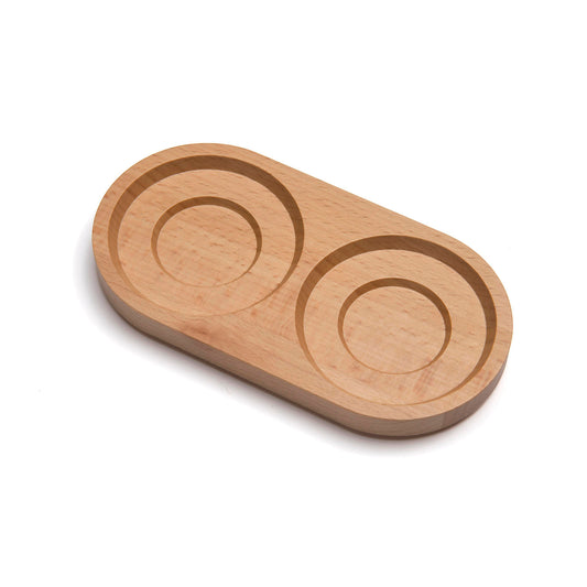 A smooth, oval wooden tray made from light-coloured wood, featuring two circular indentations. The tray has a natural finish, highlighting the wood grain, and is designed for serving or organising small items.