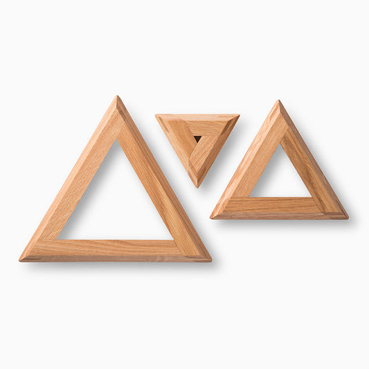 Three wooden triangular frames of varying sizes are arranged on a white background. The frames are made of light-coloured wood, showcasing a smooth finish and clean lines, creating a minimalist and modern aesthetic.