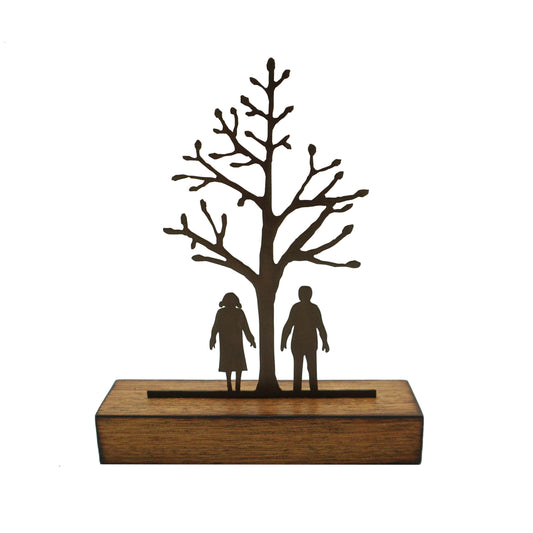A miniature sculptural artwork by David Mayne featuring a laser cut oxidised steel tree with two figures mounted on a hardwood timber block.