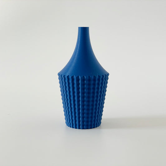 A blue 3D printed vase with a geometric ribbed design on a white background.