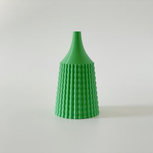 A green, 3D printed vase with a ribbed design.