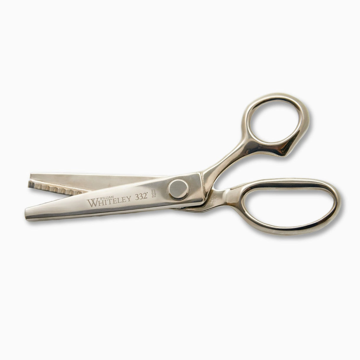 A pair of silver hairdressing scissors with a straight blade and a notched blade, featuring a rounded handle. The scissors are engraved with the name "Whiteley" and the number "332" on one side. The background is plain white.