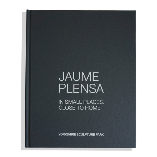 A closed book titled "Jaume Plensa: In Small Places, Close to Home" with a dark green, blue cover and white text. The book is associated with the Yorkshire Sculpture Park, suggesting a focus on the artist's work and themes.