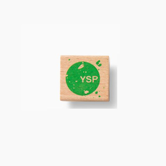 A wooden pencil sharpener featuring a green circular design with the letters "YSP" in the centre.
