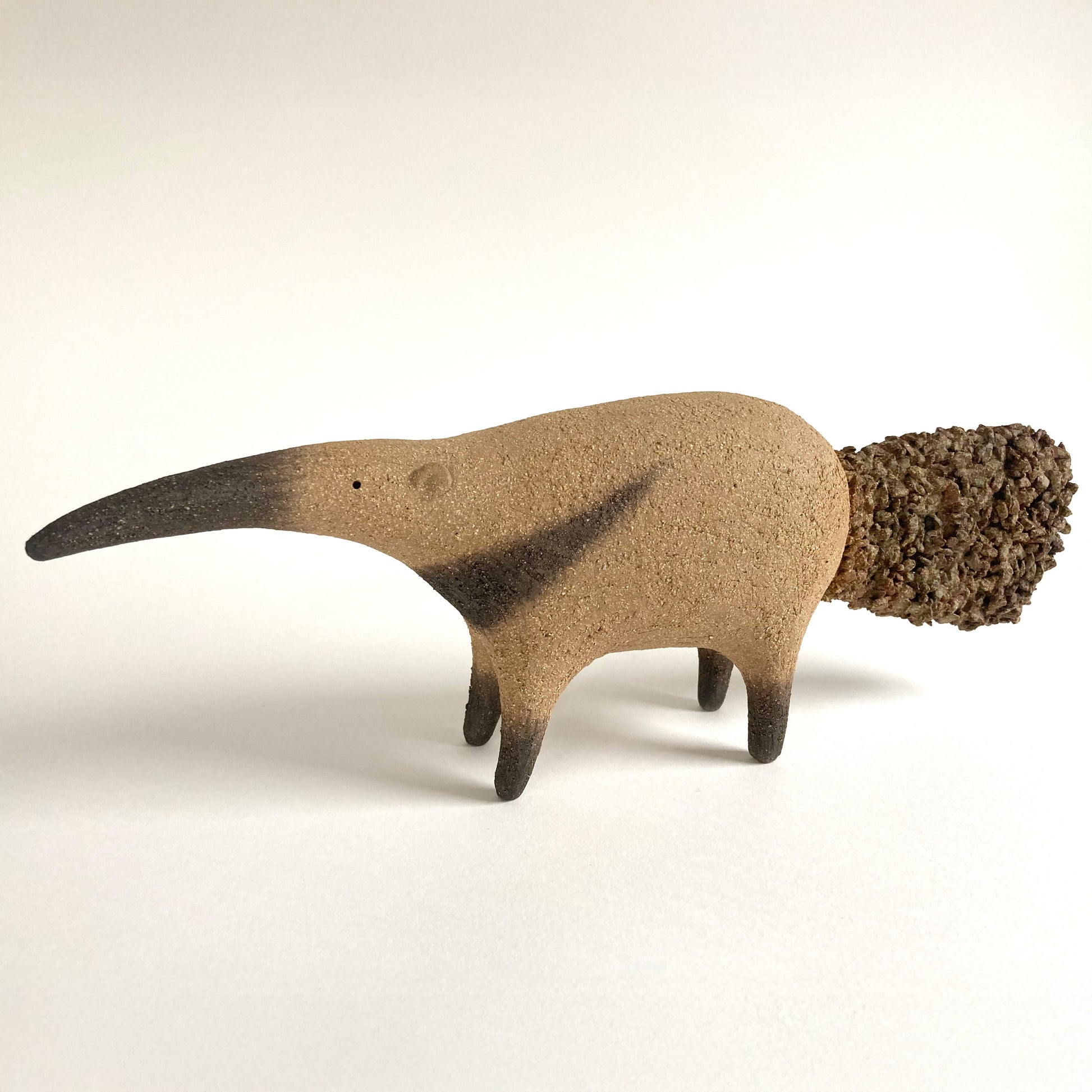 Ceramic anteater with a long slender nose and textured tail