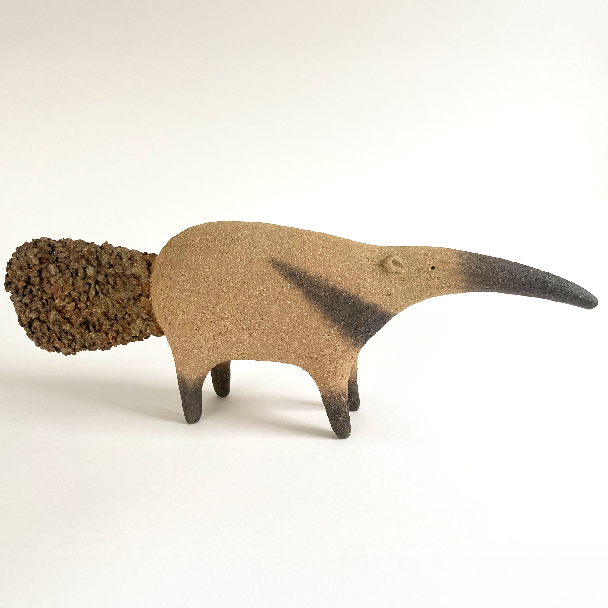 Ceramic anteater with a long slender nose and textured tail