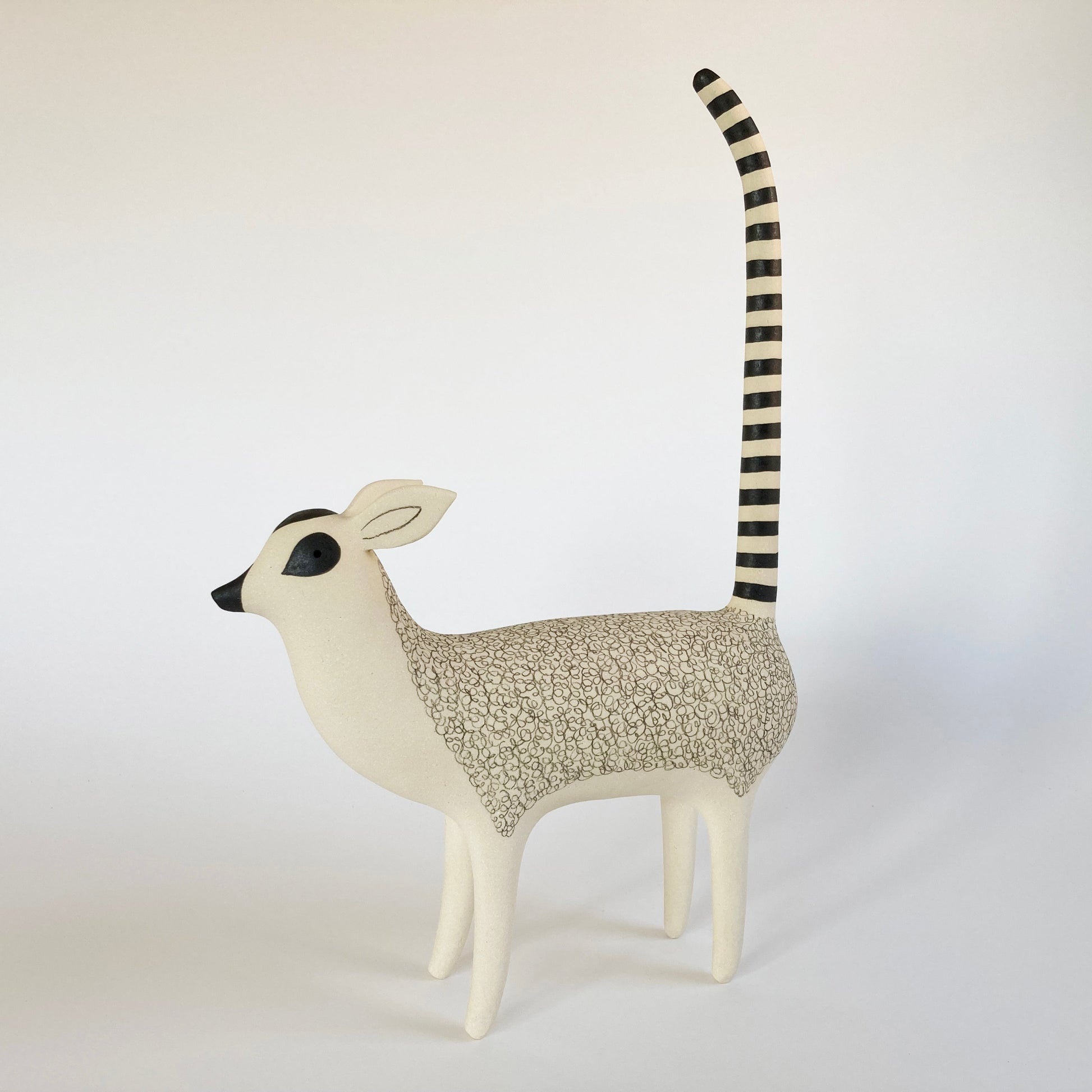 Decorative animal figure resembling a lemur on a white background