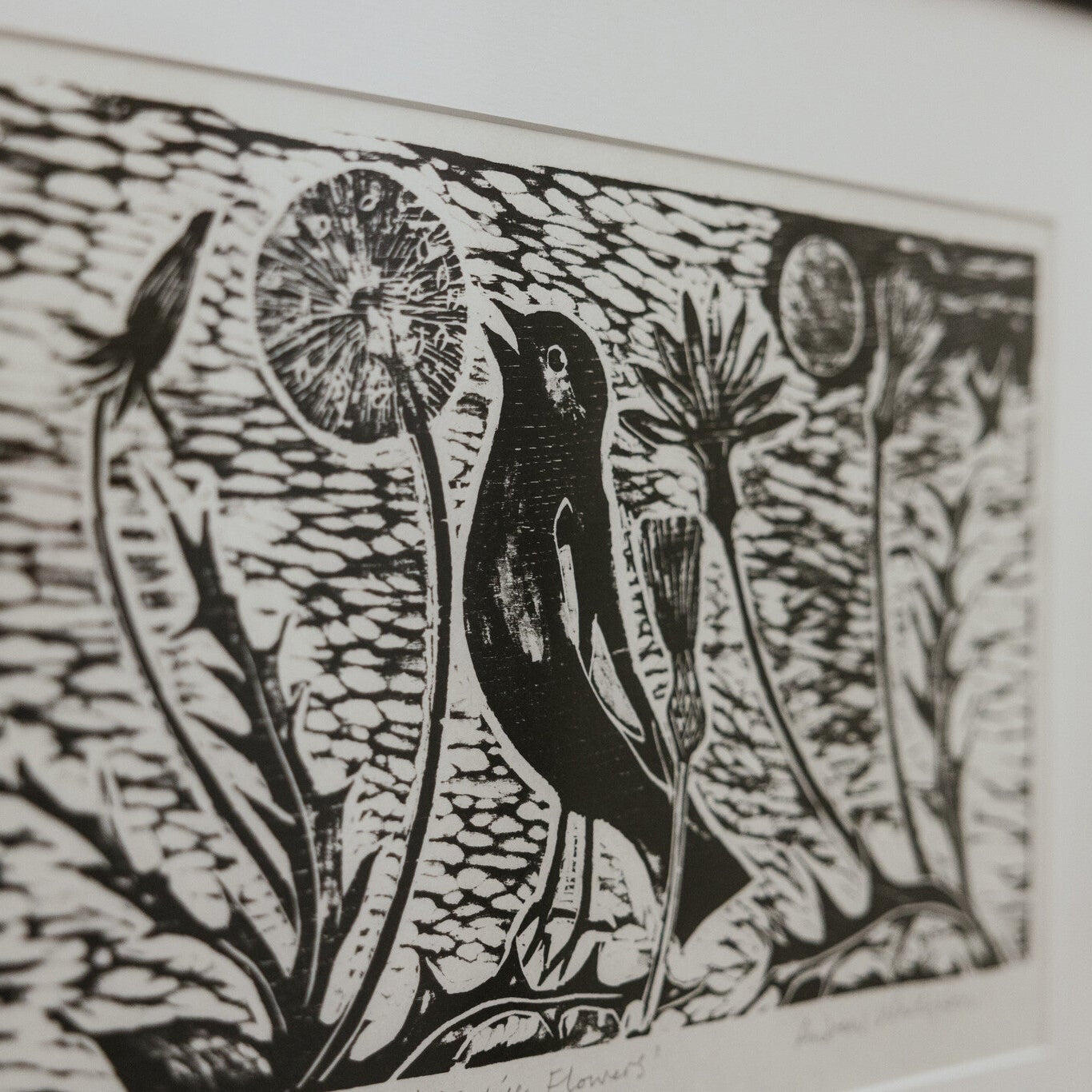 Black and white linocut print of a bird and dandelions.