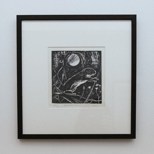 Framed black and white artwork on a light gray wall