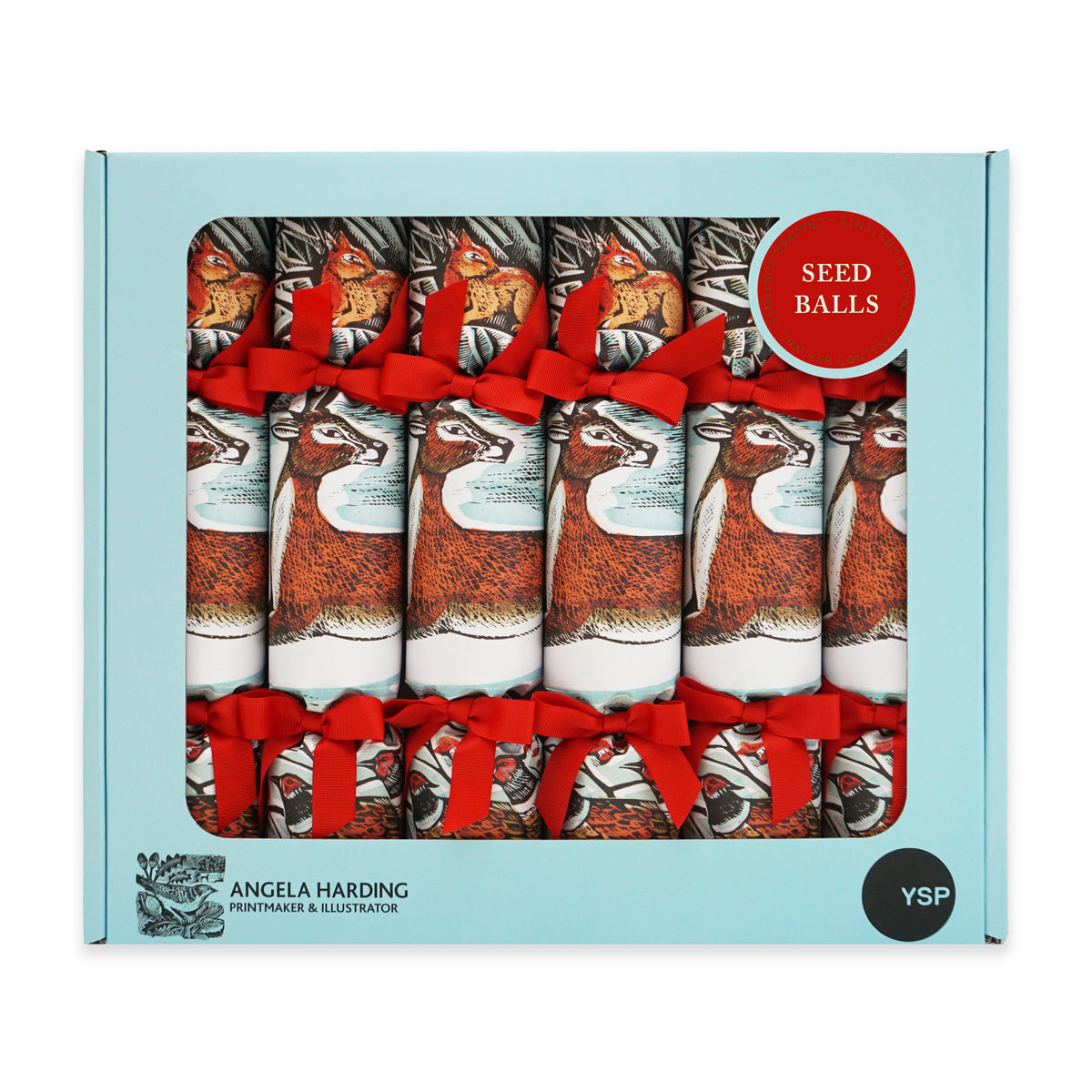 A box of six Angela Harding Christmas crackers in a light blue box with cut-out window showing six crackers with red ribbons, plus a red 'SEED BALLS' badge, a black 'YSP' circle on the front and Angela Harding branding. The cracker design features a red deer, a red squirrel and a pheasant.
