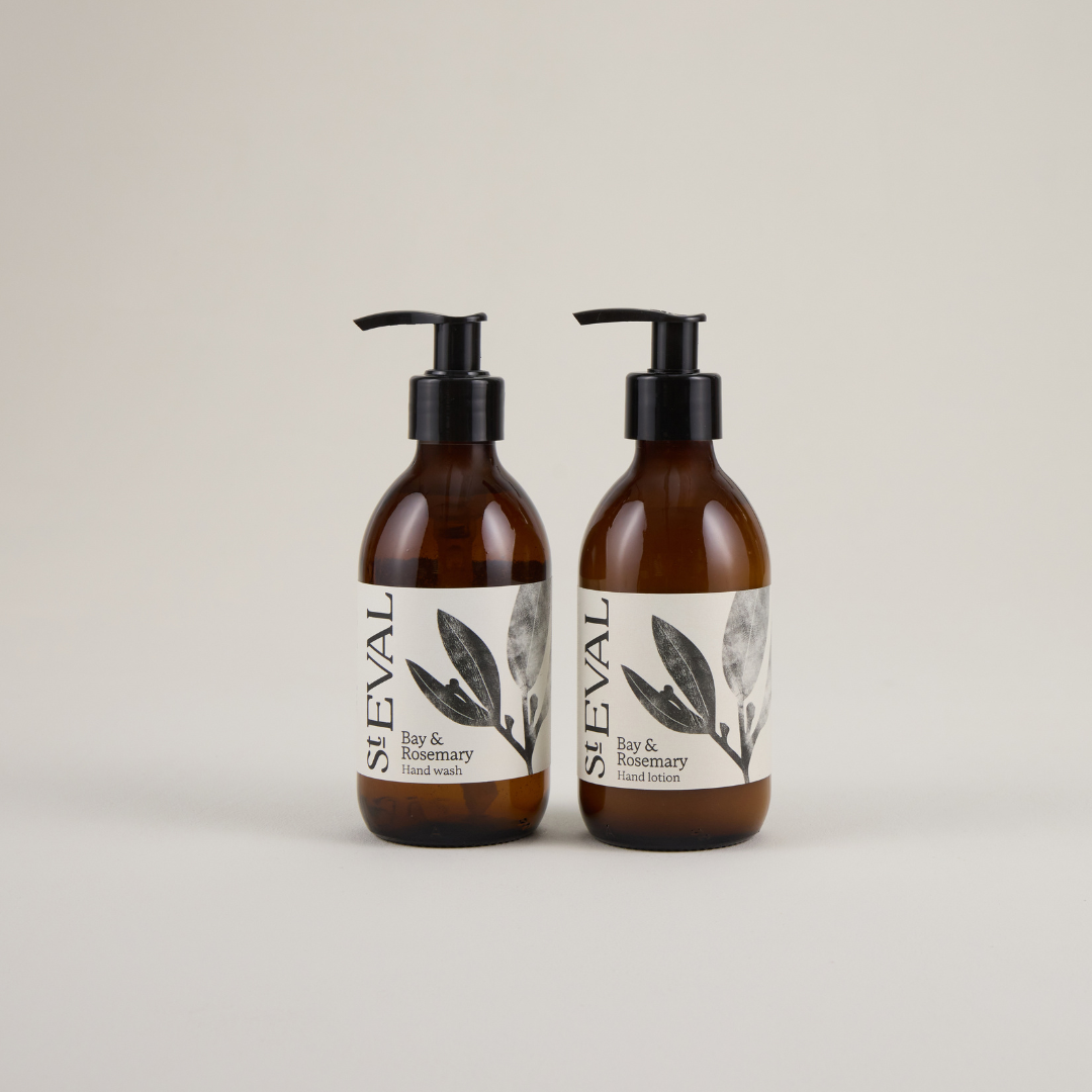 Two brown glass jars with pumps and a foliage design on the beige label.