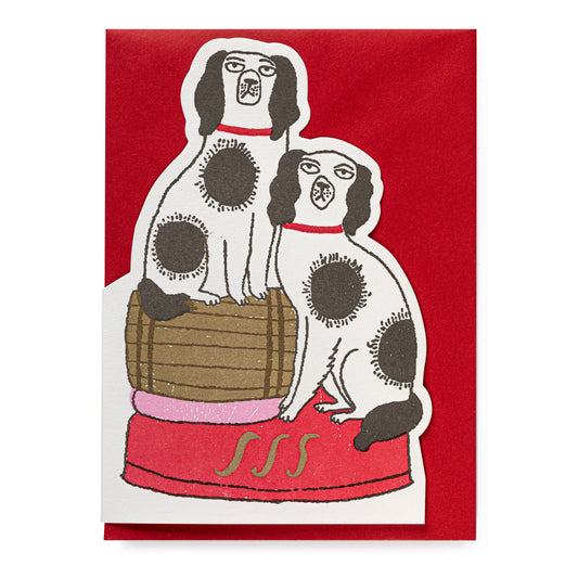 Illustration of two dogs with spots, standing on a barrel. Card is on a red envelope