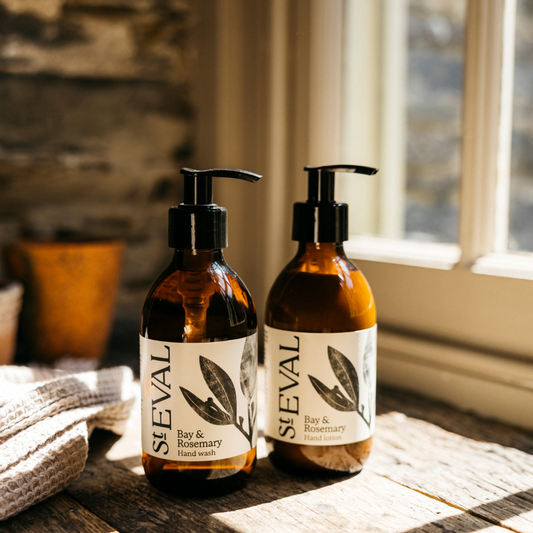 Two brown bottles with pumps and white label sitting on a wooden worktop surrounded by natural light from the window.