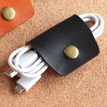 A black cable wrap with a brass popper.