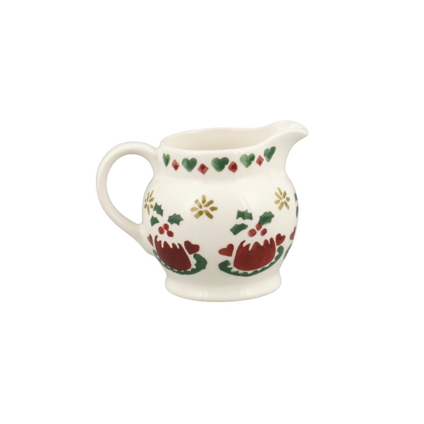 A small white ceramic pitcher decorated with a festive Christmas pattern featuring red Christmas puddings, green leaves, and gold stars, set against a plain white background.