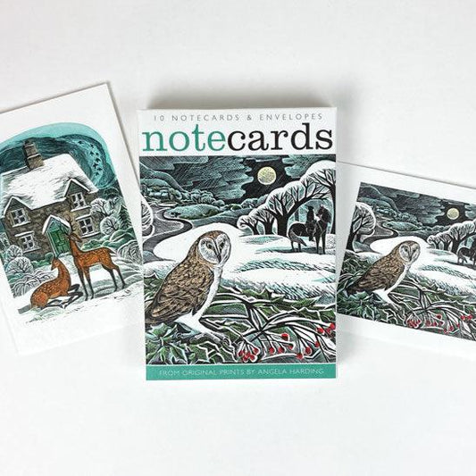 A pack of Christmas notecards featuring two original works by print maker Angela Harding. The vibes are festive, snowy and wintery with depictions of deer and an owl. 