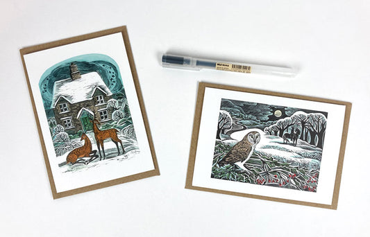 A pack of Christmas notecards featuring two original works by print maker Angela Harding. The vibes are festive, snowy and wintery with depictions of deer and an owl. 
