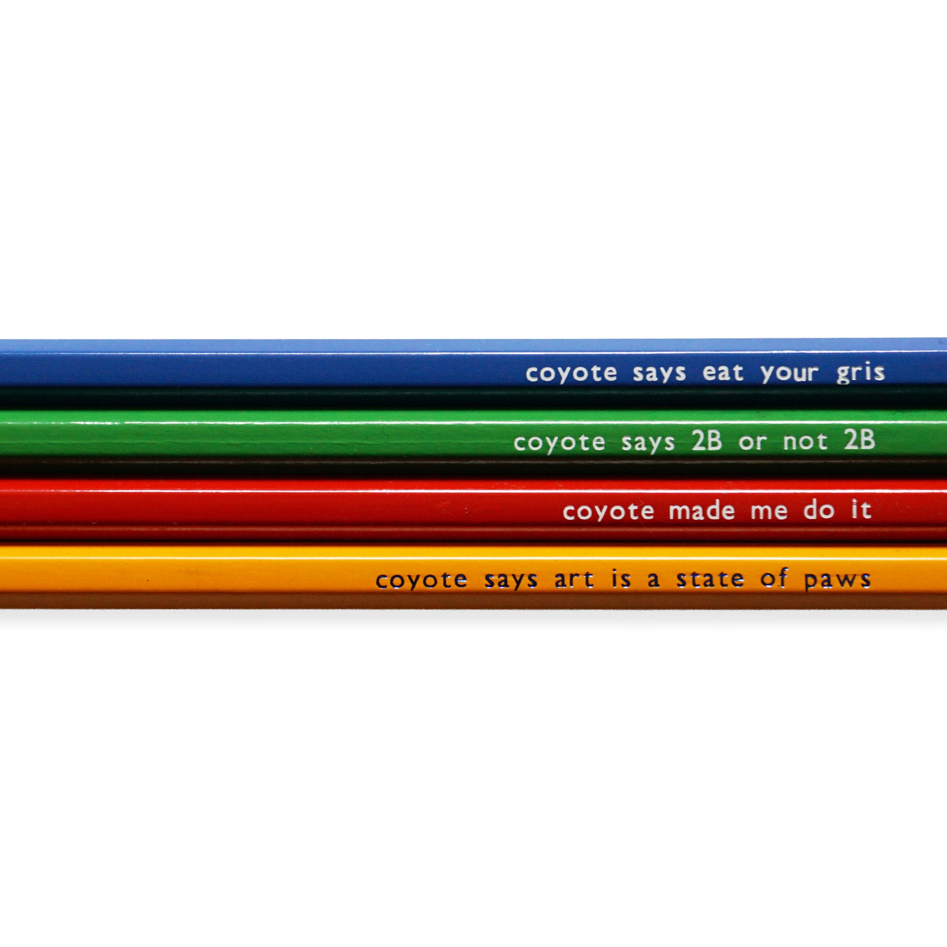 Four coloured pencils with humorous text: blue with "coyote says eat your gris," green with "coyote says 2B or not 2B," red with "coyote made me do it," and orange with "coyote says art is a state of paws".