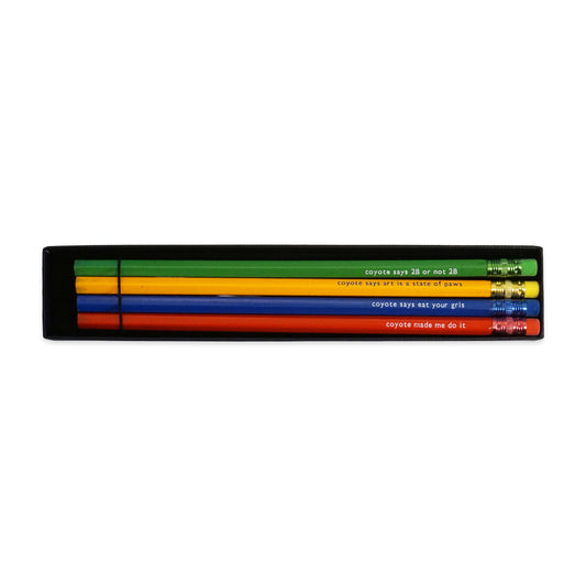 A set of four pencils in a black box, each a different colour: yellow, green, red, and blue. Each pencil has a humorous phrase printed in white, such as "coyote says 2B or not 2B" and "coyote made me do it".