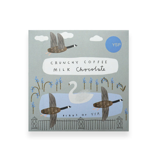 A square blue cardboard packet of chocolate featuring illustrations of geese, flowers, a pond and a swan.