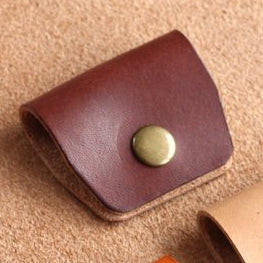 A leather dark brown cable wrap with a brass popper