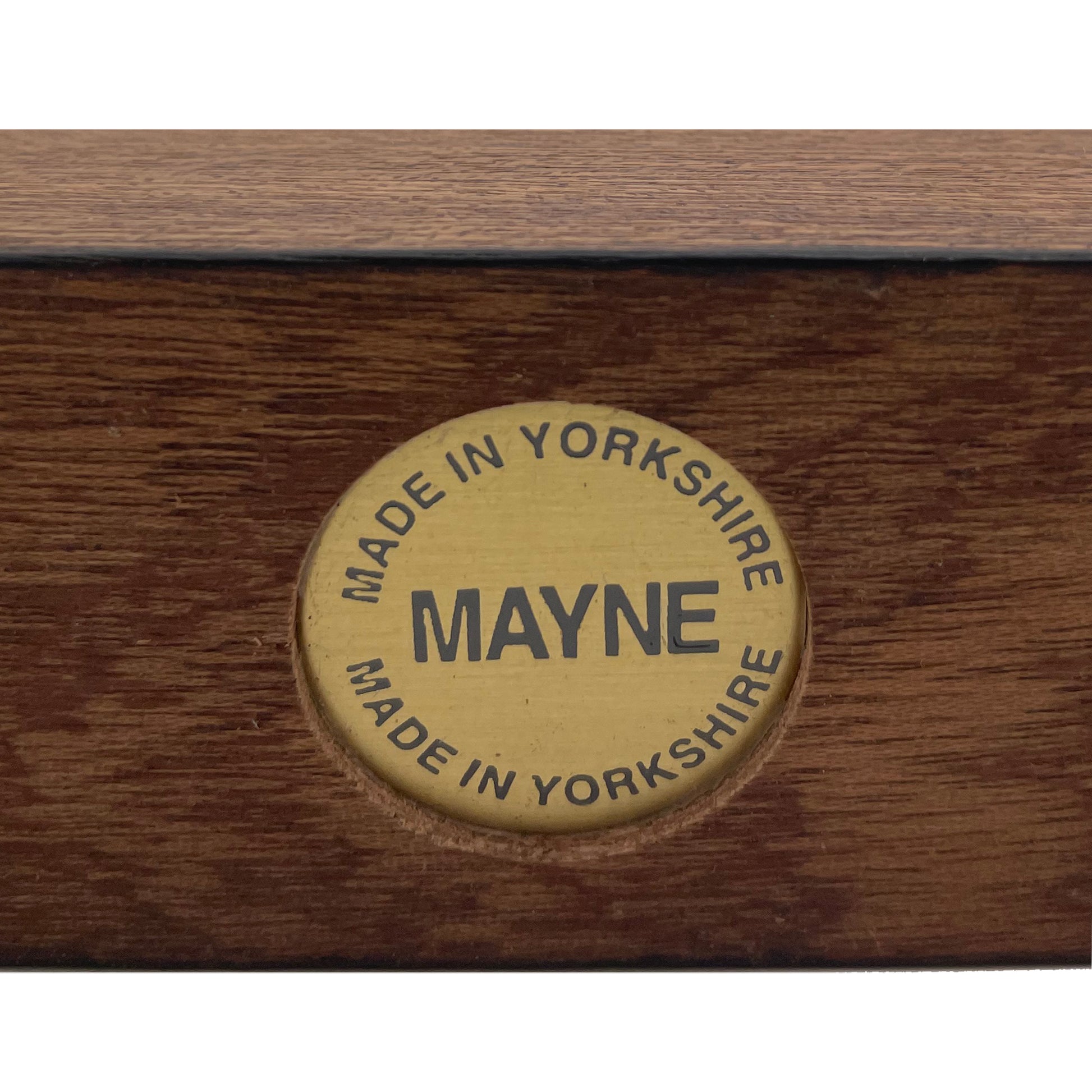 A brass circular disc base stamp featuring the words 'Made In Yorkshire and 'Mayne'.