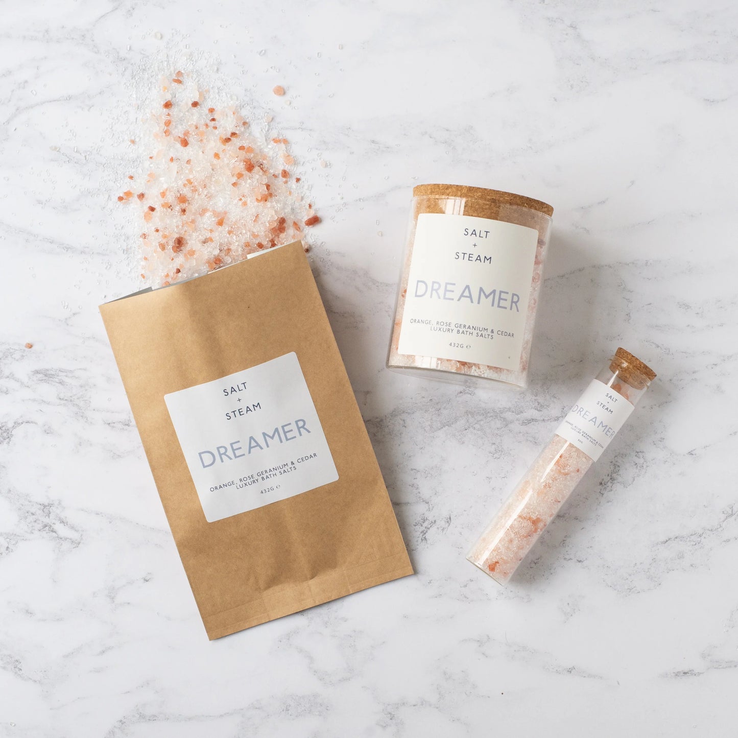Bath salt packaging with 'Dreamer' branding on a marble surface