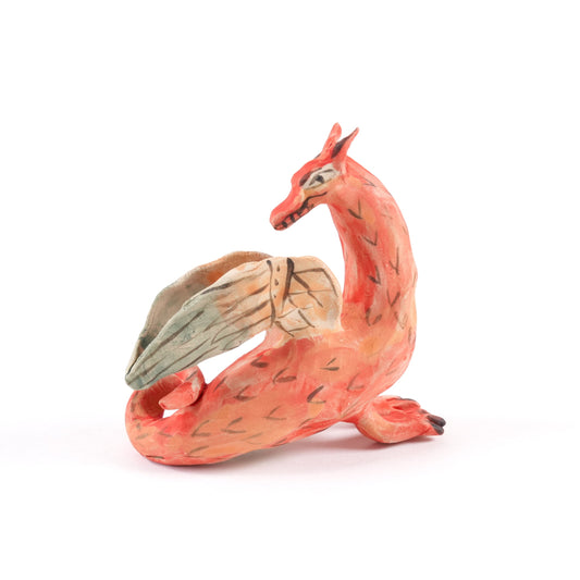 A painted ceramic dragon whistle in shades of orange on a plain white background.