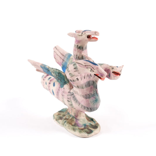 Colourful dragon-like ceramic whistle on a white background. The hydra has three heads, wings and a tail.