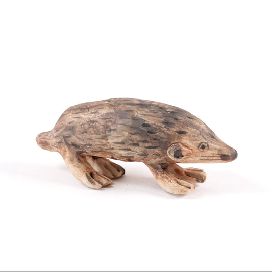A painted ceramic mole whistle in shades of brown on a plain white background.