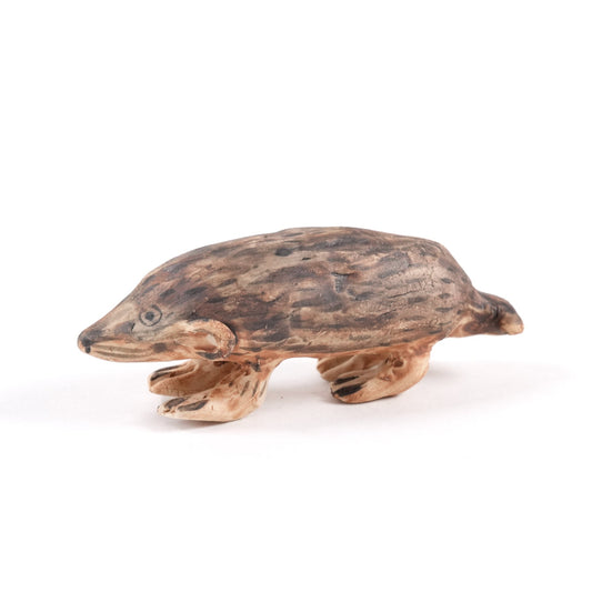 A painted ceramic mole whistle in shades of brown on a plain white background.