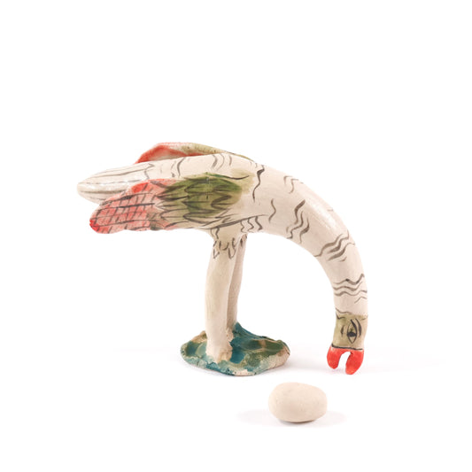 A painted ceramic ostrich whistle in shades of beige, orange and green on a plain white background.