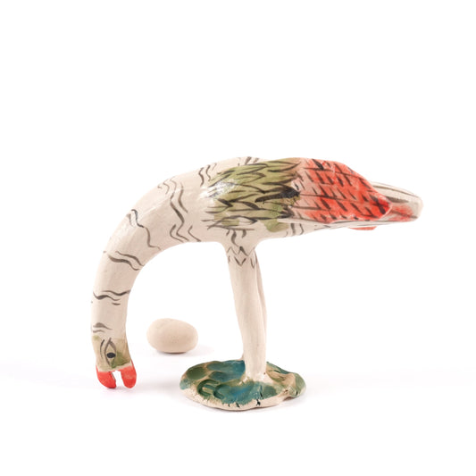 A painted ceramic ostrich whistle in shades of beige, orange and green on a plain white background.